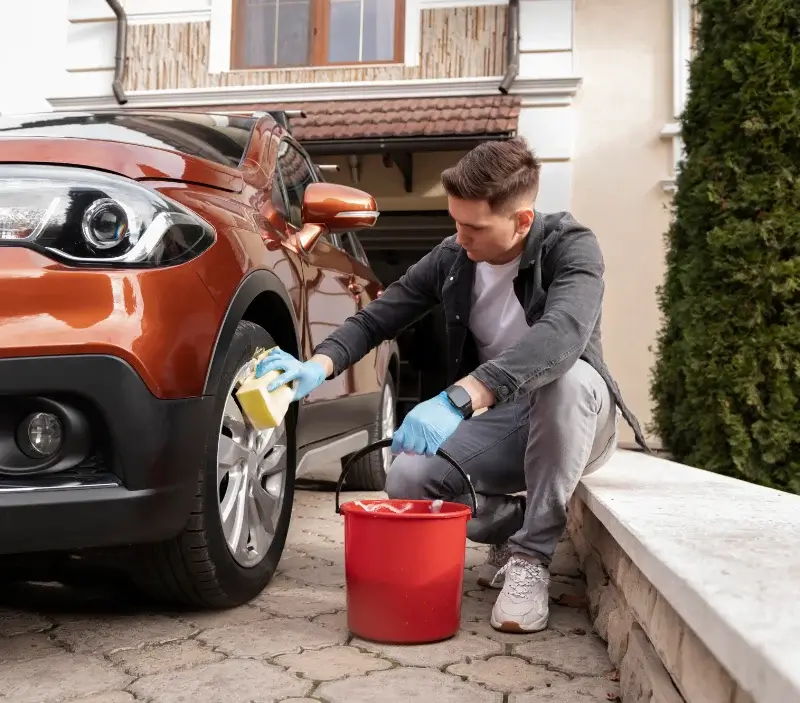 Lavage auto à domicile Juvigné : professionnel intervenant sur un véhicule